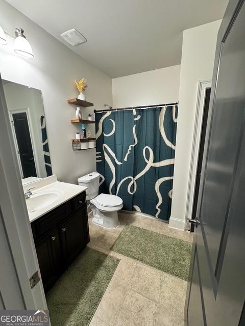 bathroom with curtained shower, tile patterned flooring, vanity, and toilet