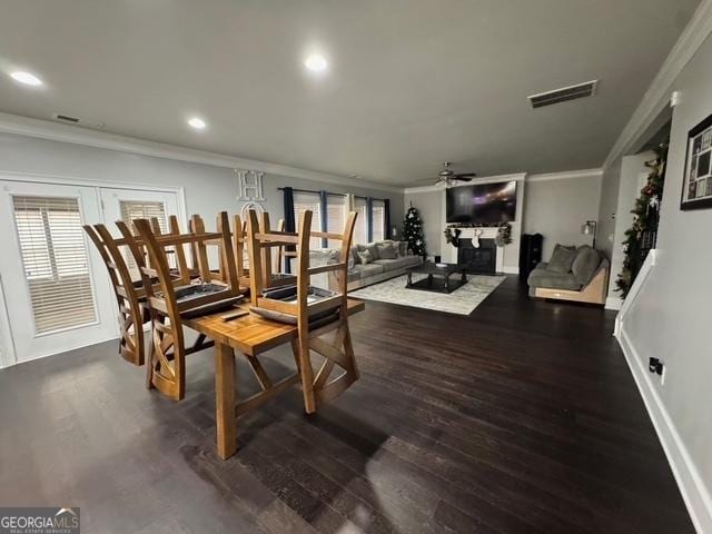 dining area featuring ceiling fan, wood finished floors, visible vents, baseboards, and crown molding