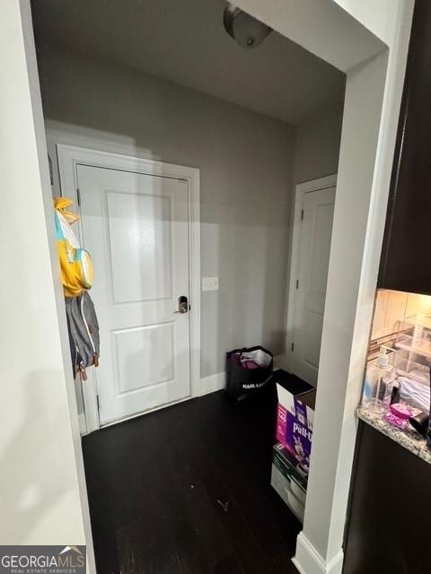 interior space featuring dark wood-style flooring and baseboards