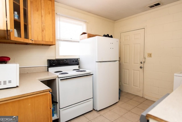 kitchen with white appliances, light tile patterned floors, visible vents, ornamental molding, and light countertops