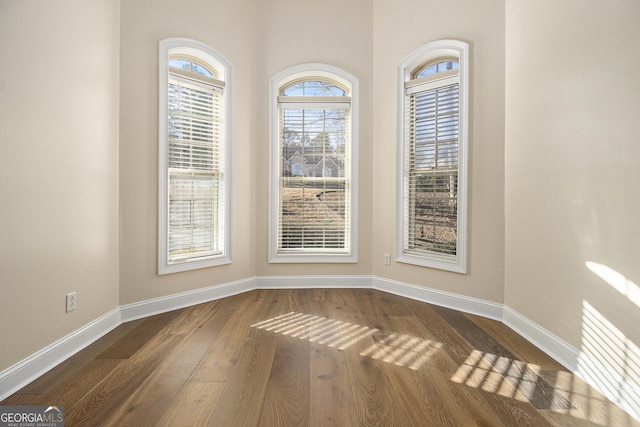 interior space featuring dark wood-type flooring and baseboards