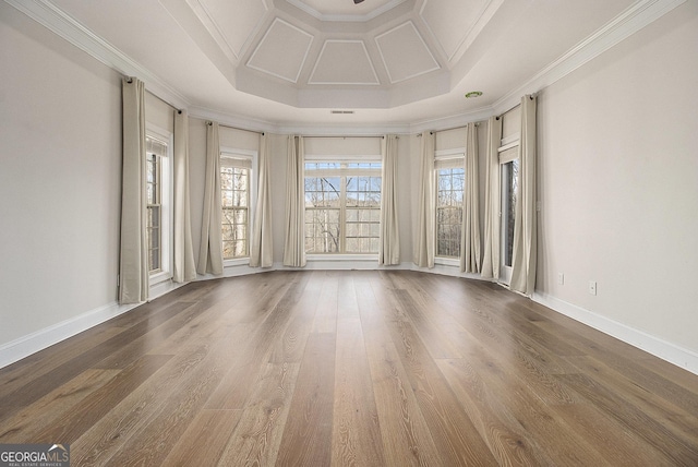 unfurnished room featuring ornamental molding, coffered ceiling, wood finished floors, and baseboards