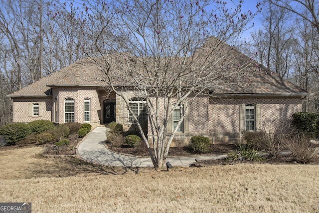 view of front of house featuring a front lawn and brick siding