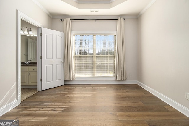 interior space featuring baseboards, crown molding, and wood finished floors