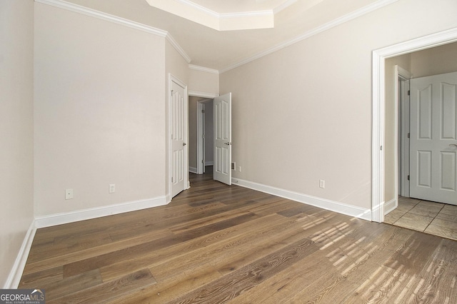 unfurnished bedroom featuring baseboards, wood finished floors, and crown molding