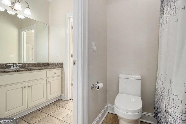 bathroom featuring tile patterned flooring, baseboards, vanity, and toilet