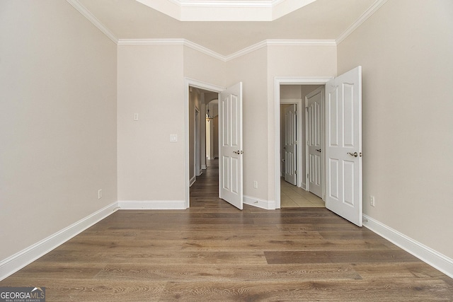 unfurnished bedroom with baseboards, wood finished floors, and crown molding