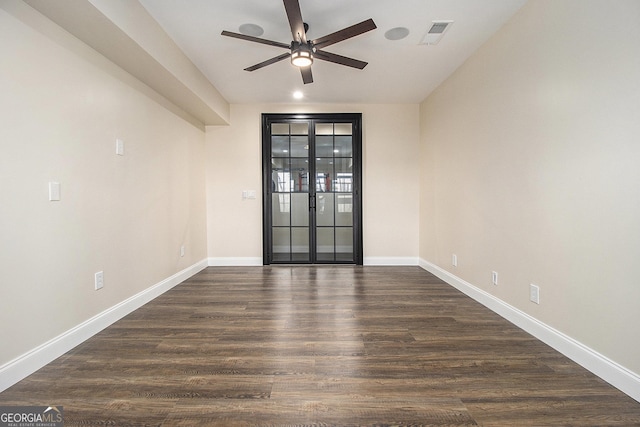 unfurnished room featuring visible vents, baseboards, ceiling fan, and dark wood-style flooring