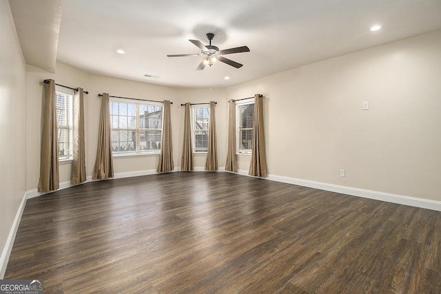 empty room featuring dark wood-type flooring, recessed lighting, and baseboards