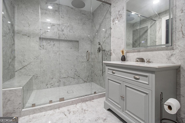 full bath featuring tile walls, marble finish floor, vanity, and a marble finish shower