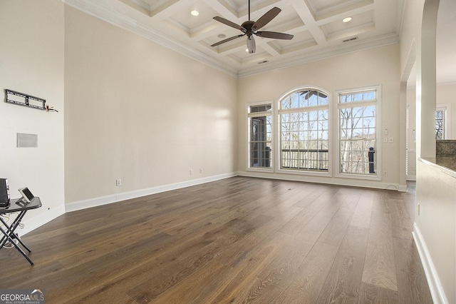 unfurnished room featuring coffered ceiling, a towering ceiling, a ceiling fan, beamed ceiling, and dark wood finished floors