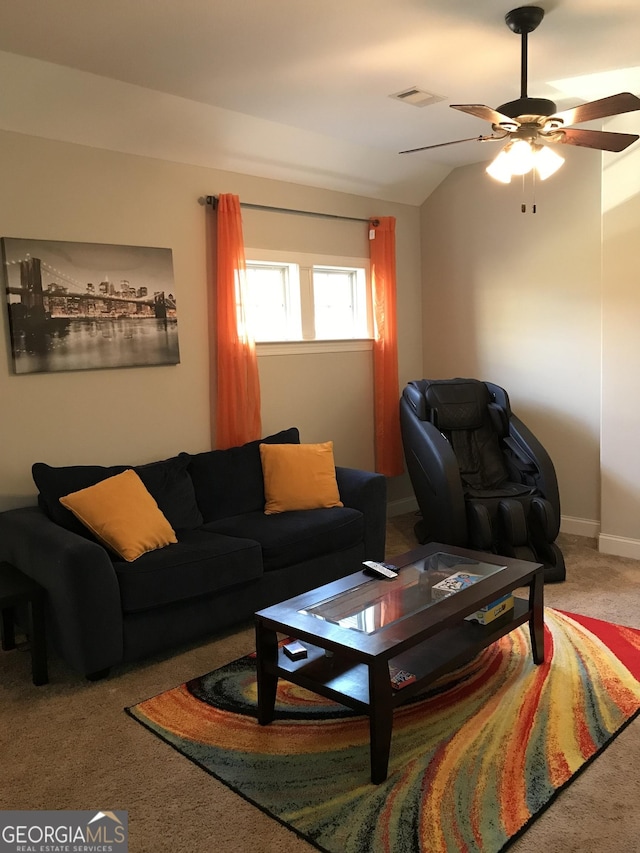 carpeted living room with baseboards, visible vents, vaulted ceiling, and a ceiling fan