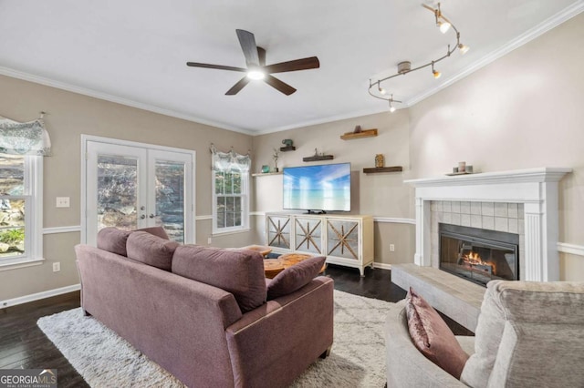 living area with a tile fireplace, dark wood finished floors, and crown molding