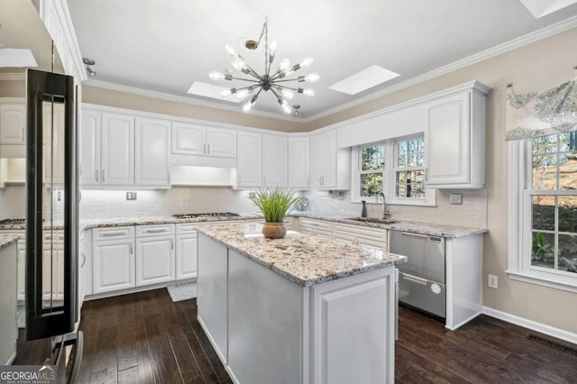 kitchen featuring black refrigerator, a sink, white cabinetry, and stainless steel gas stovetop