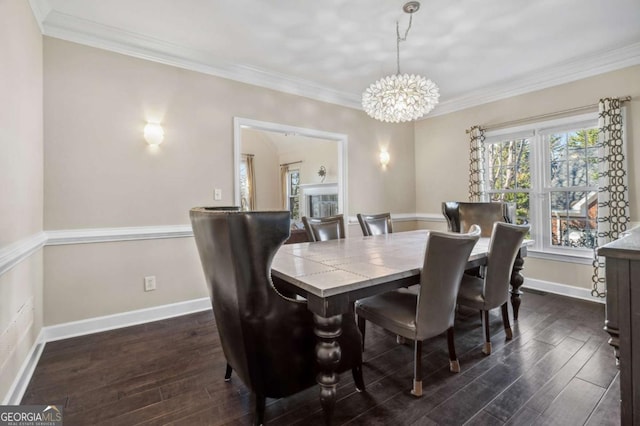 dining area with crown molding, dark wood-style flooring, a chandelier, and baseboards