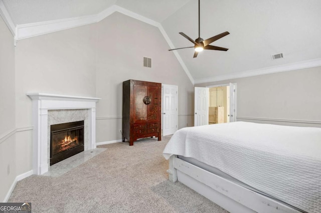 bedroom featuring visible vents, a premium fireplace, ornamental molding, a ceiling fan, and carpet flooring