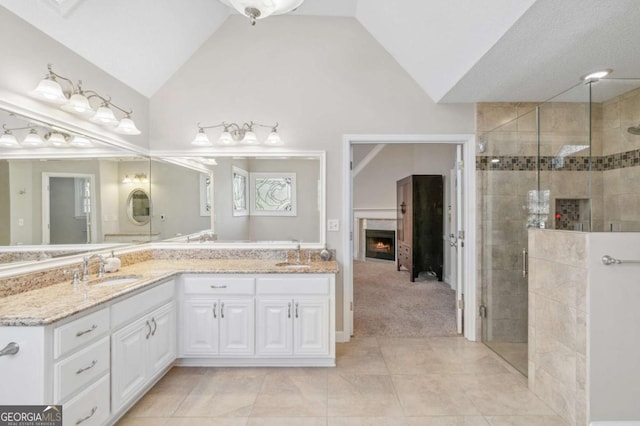 full bathroom featuring a shower stall, a sink, and a lit fireplace