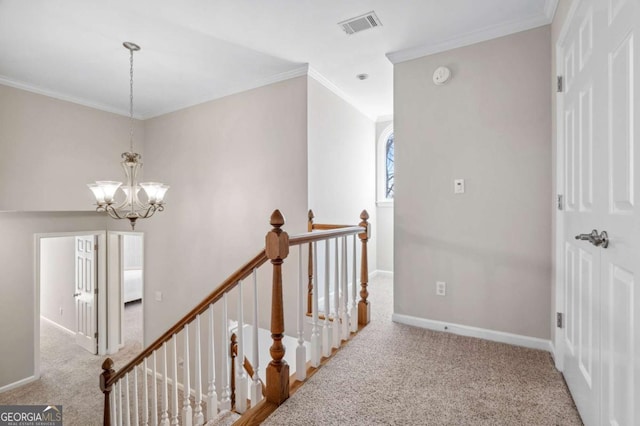 hallway with visible vents, carpet, crown molding, an upstairs landing, and a chandelier