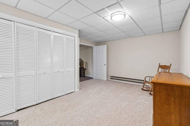 sitting room with a baseboard heating unit, carpet flooring, and a drop ceiling