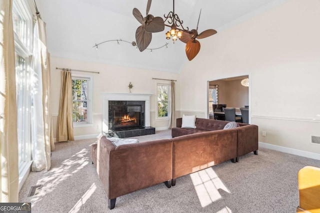 carpeted living area with high vaulted ceiling, plenty of natural light, a fireplace, and visible vents