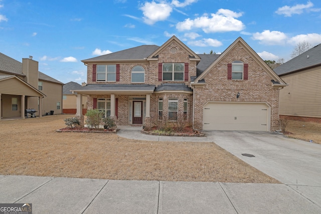 view of front facade featuring brick siding, a porch, a garage, driveway, and a front lawn