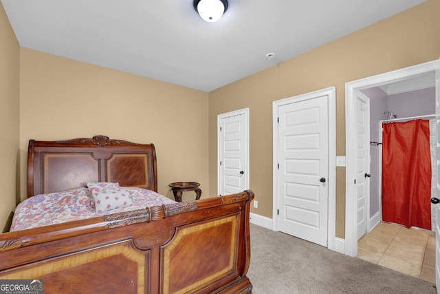 bedroom featuring light carpet, light tile patterned floors, and baseboards