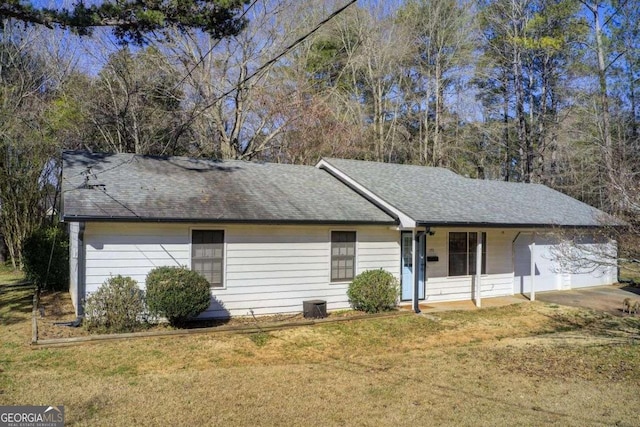 ranch-style home featuring an attached garage, a front lawn, and roof with shingles