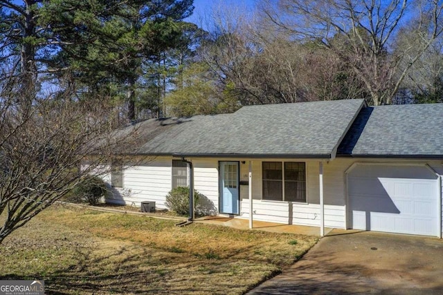 ranch-style house with a garage, covered porch, driveway, roof with shingles, and a front yard