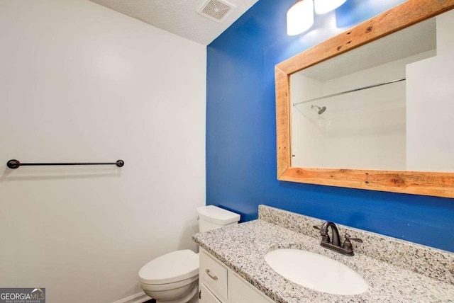 bathroom with baseboards, visible vents, vanity, and toilet