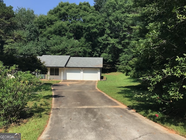170 Roberts Rd, Covington, GA 30016 - view of front of house featuring a front yard, driveway, a garage, and a wooded view