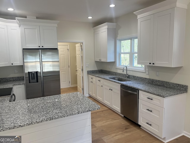 kitchen with light wood-style flooring, stainless steel appliances, a sink, and recessed lighting