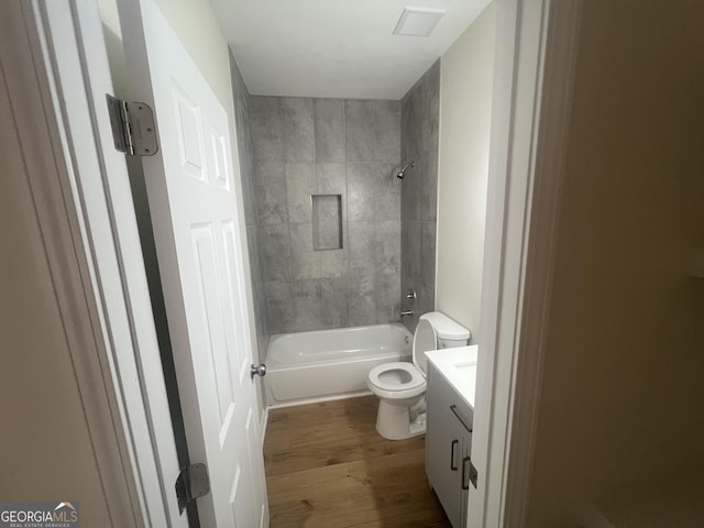 bathroom with toilet, shower / bath combination, wood finished floors, and vanity