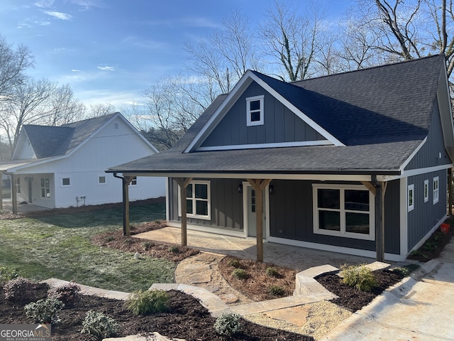 view of front of property with covered porch, a shingled roof, and board and batten siding