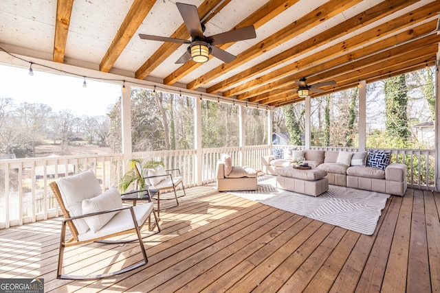 sunroom / solarium with beam ceiling and a ceiling fan