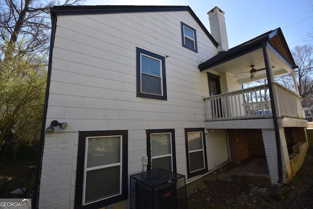 rear view of house featuring ceiling fan and a chimney