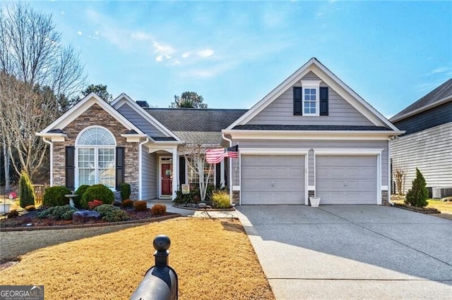 view of front of property with stone siding, concrete driveway, and a front yard