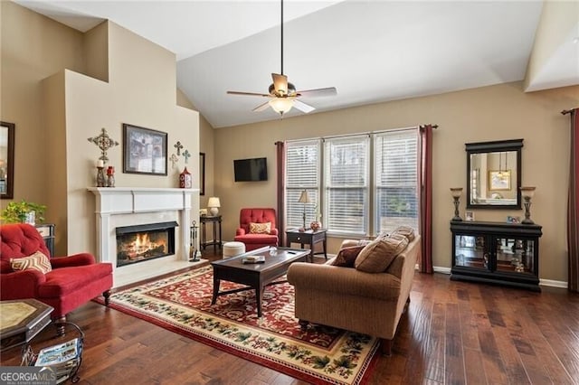 living area featuring ceiling fan, a fireplace with flush hearth, baseboards, vaulted ceiling, and hardwood / wood-style floors