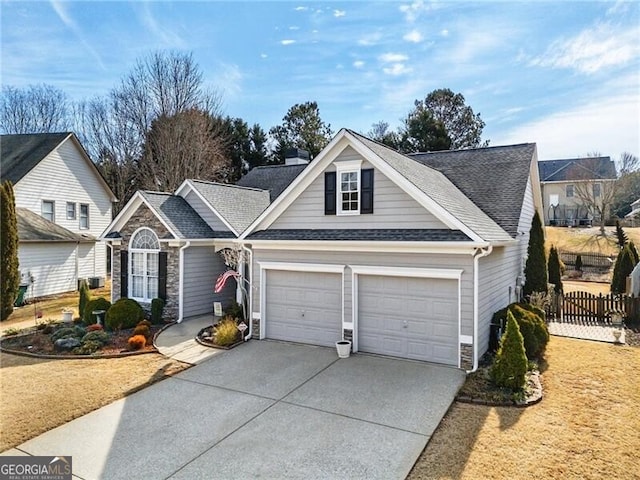 view of front of house with a chimney, an attached garage, fence, stone siding, and driveway