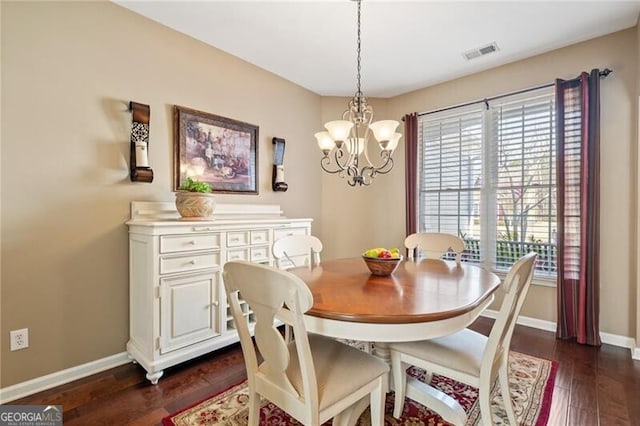 dining space with dark wood-style floors, baseboards, visible vents, and a notable chandelier