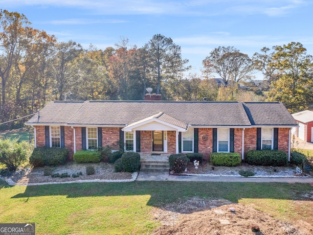 ranch-style house featuring a front yard, brick siding, and roof with shingles