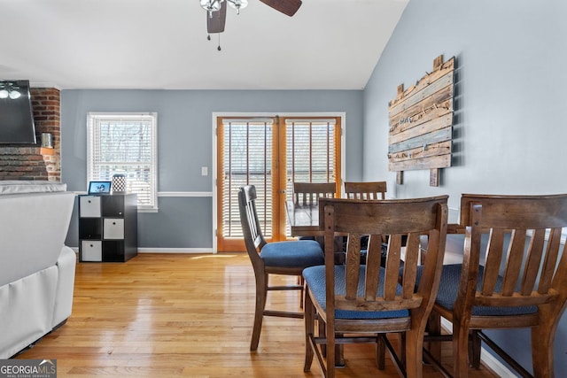 dining area with lofted ceiling, ceiling fan, light wood finished floors, and baseboards