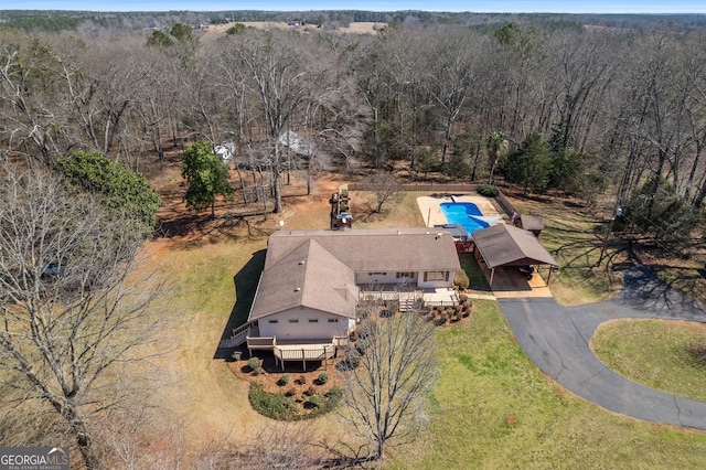 birds eye view of property featuring a forest view