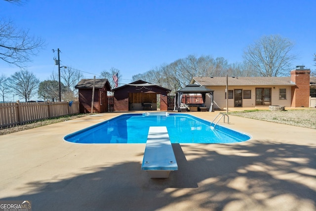 view of swimming pool featuring a fenced in pool, an outbuilding, a gazebo, fence, and a diving board