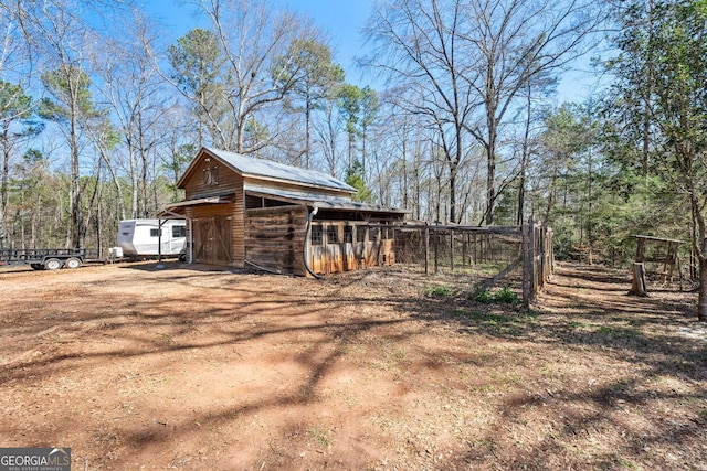 view of property exterior featuring an outdoor structure and driveway