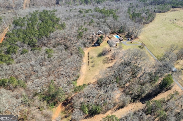 bird's eye view with a wooded view