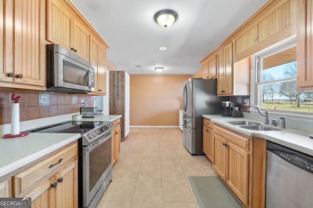 kitchen featuring stainless steel appliances, tasteful backsplash, a sink, and light countertops