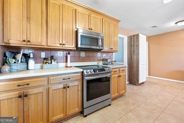 kitchen with visible vents, appliances with stainless steel finishes, light countertops, and backsplash