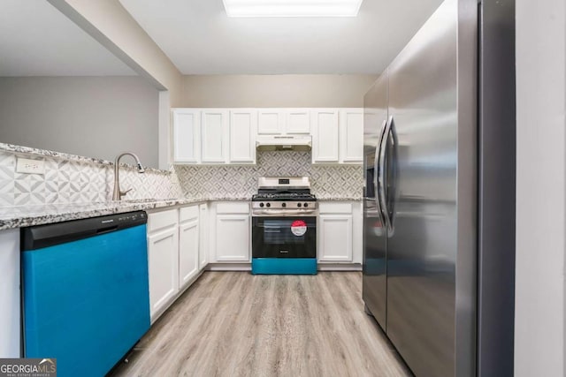 kitchen featuring under cabinet range hood, a sink, white cabinetry, appliances with stainless steel finishes, and backsplash