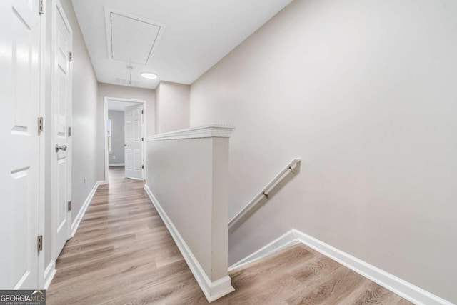 hall with attic access, baseboards, an upstairs landing, and wood finished floors