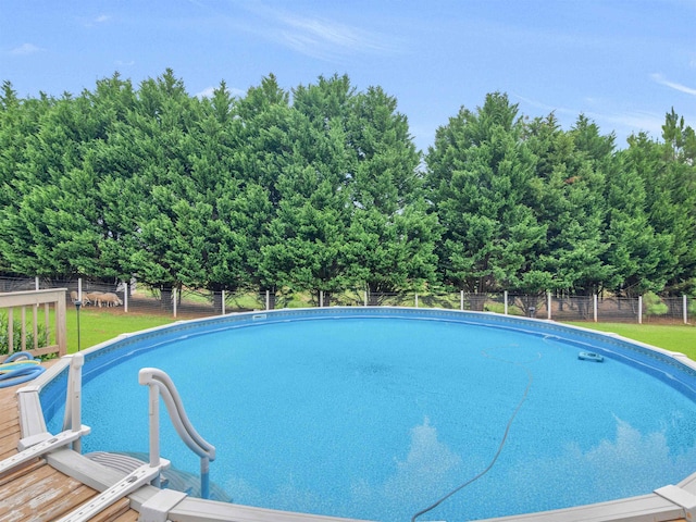 outdoor pool featuring a yard and fence